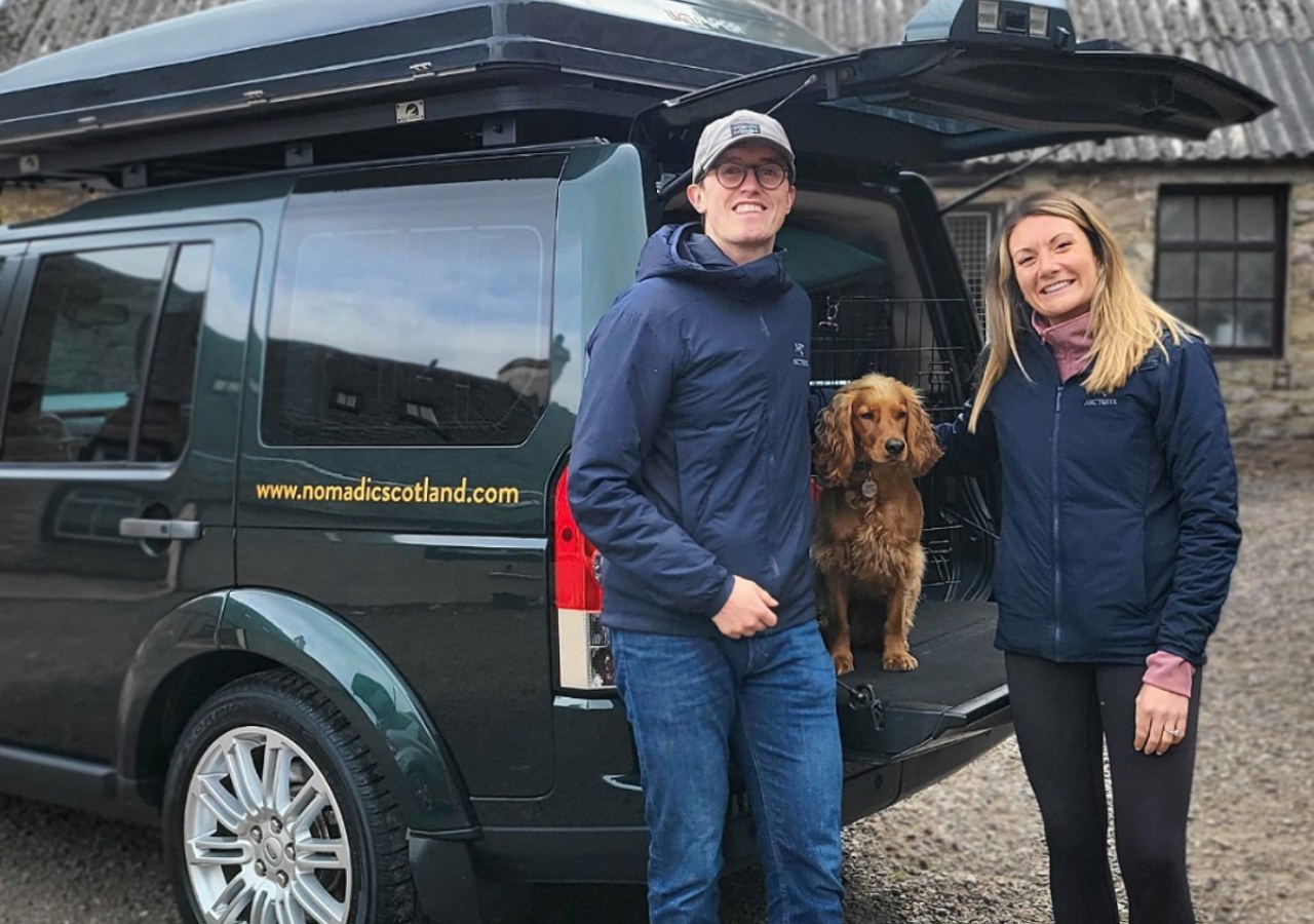 A couple and their dog on holidays in Scotland with a highland camper hire Discovery.