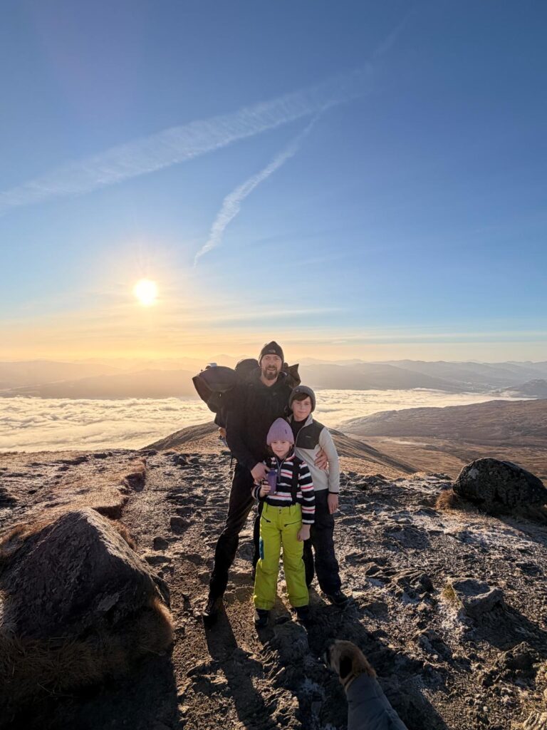 Family standing at the top of a munro