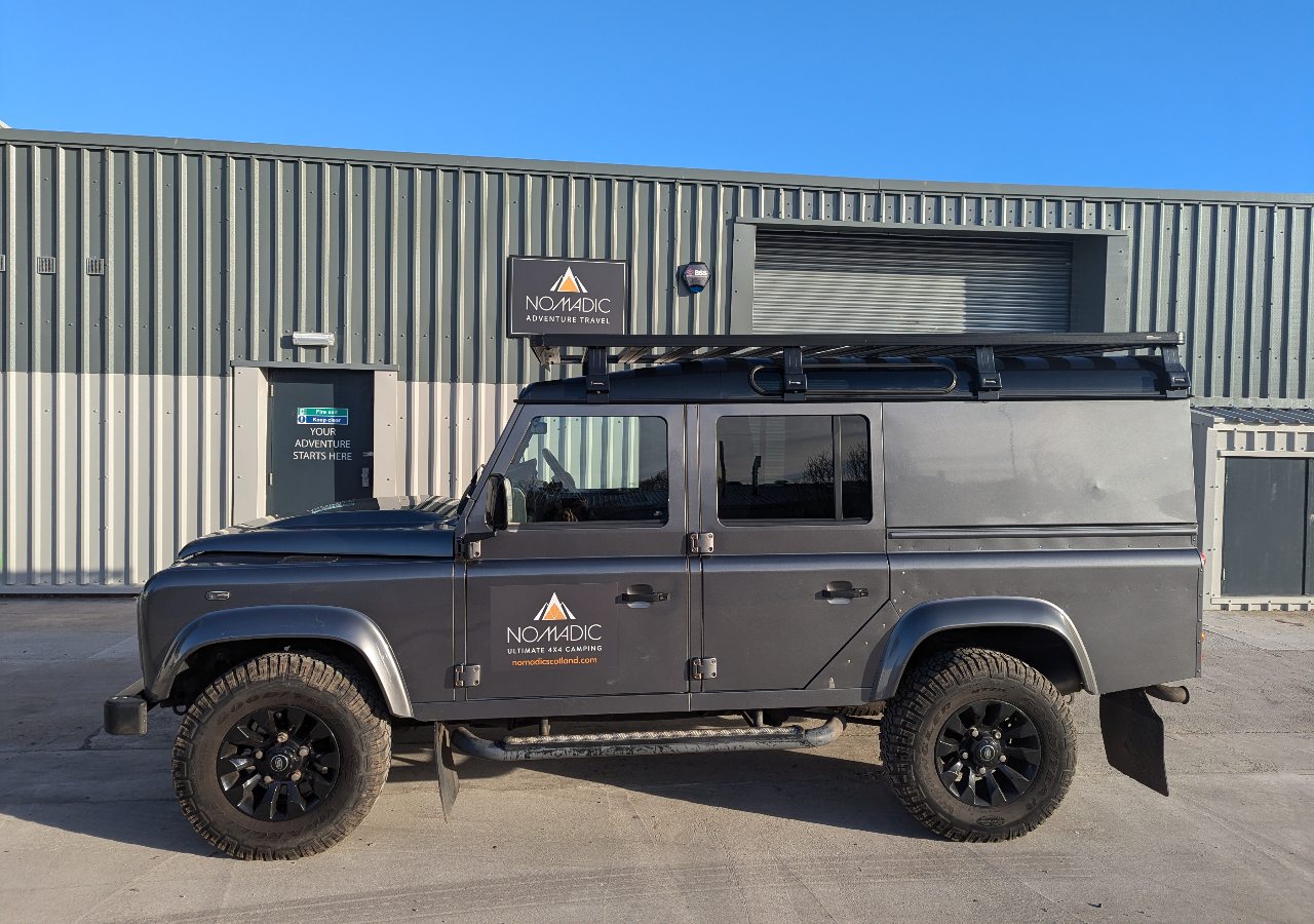 A Landrover defender 4x4 vehicle for hire on a sunny day in Scotland.