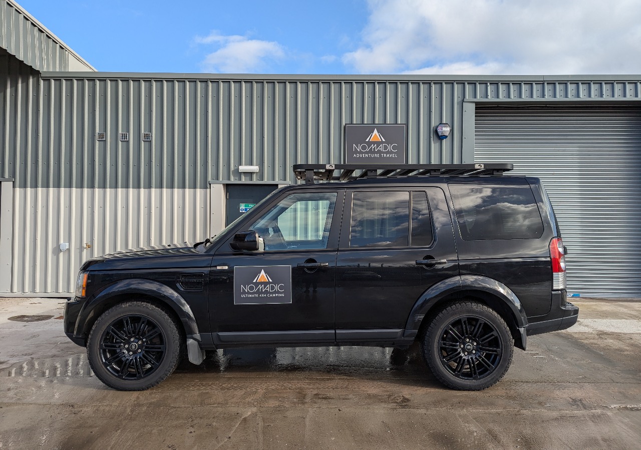 A Land Rover Discovery 4x4 vehicle for hire on a sunny day in Scotland.