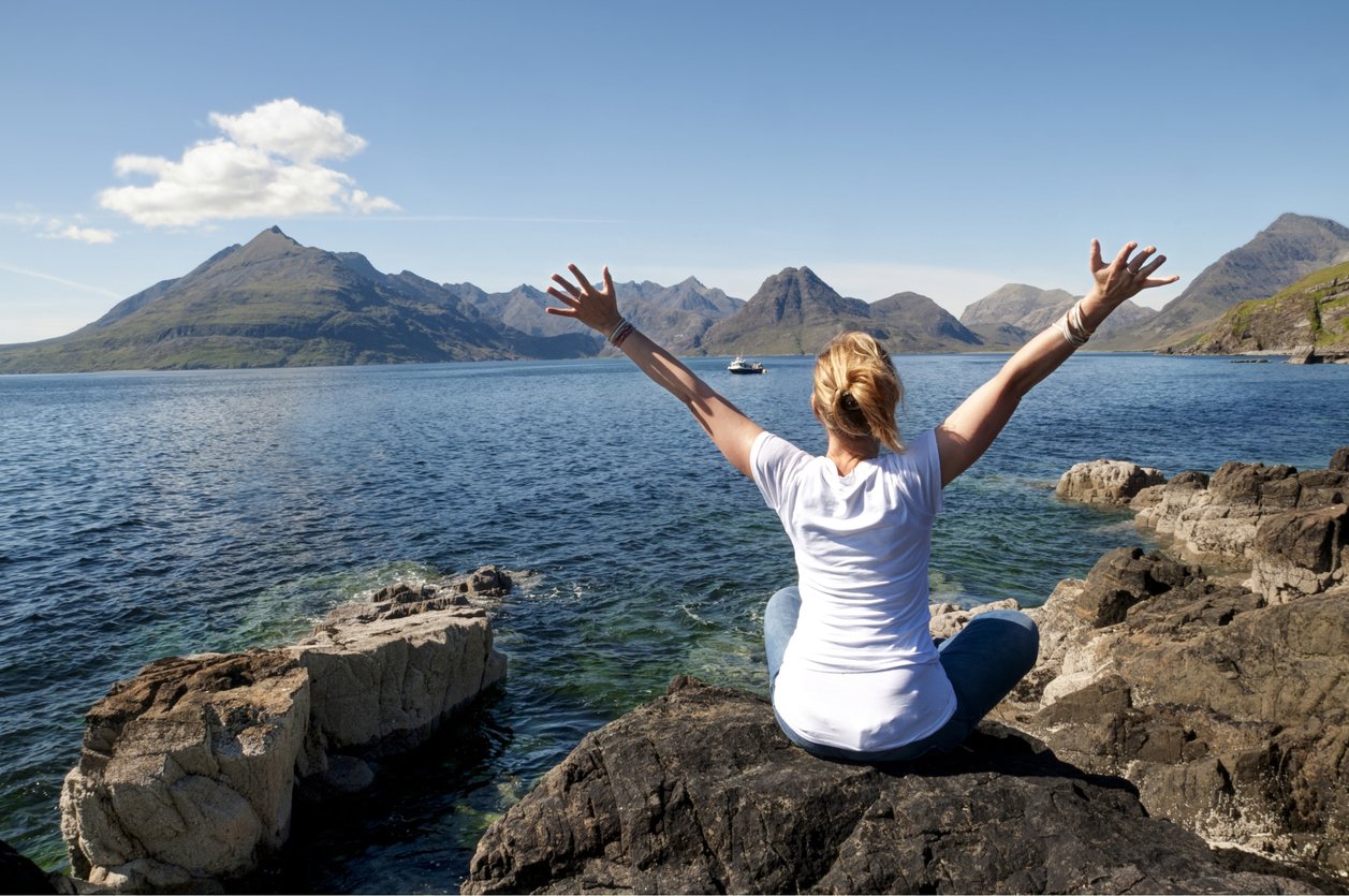 Lady sitting on cliffs by sea