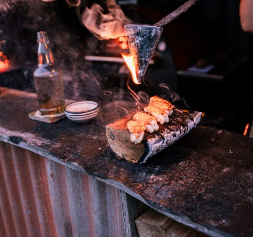 Food cooking over open flames at the outdoor kitchen