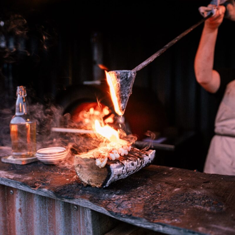 A chef cooking over an open fire at Inverlonan