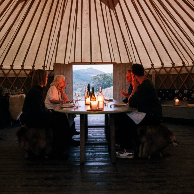 A long table set in a candlelit cabin